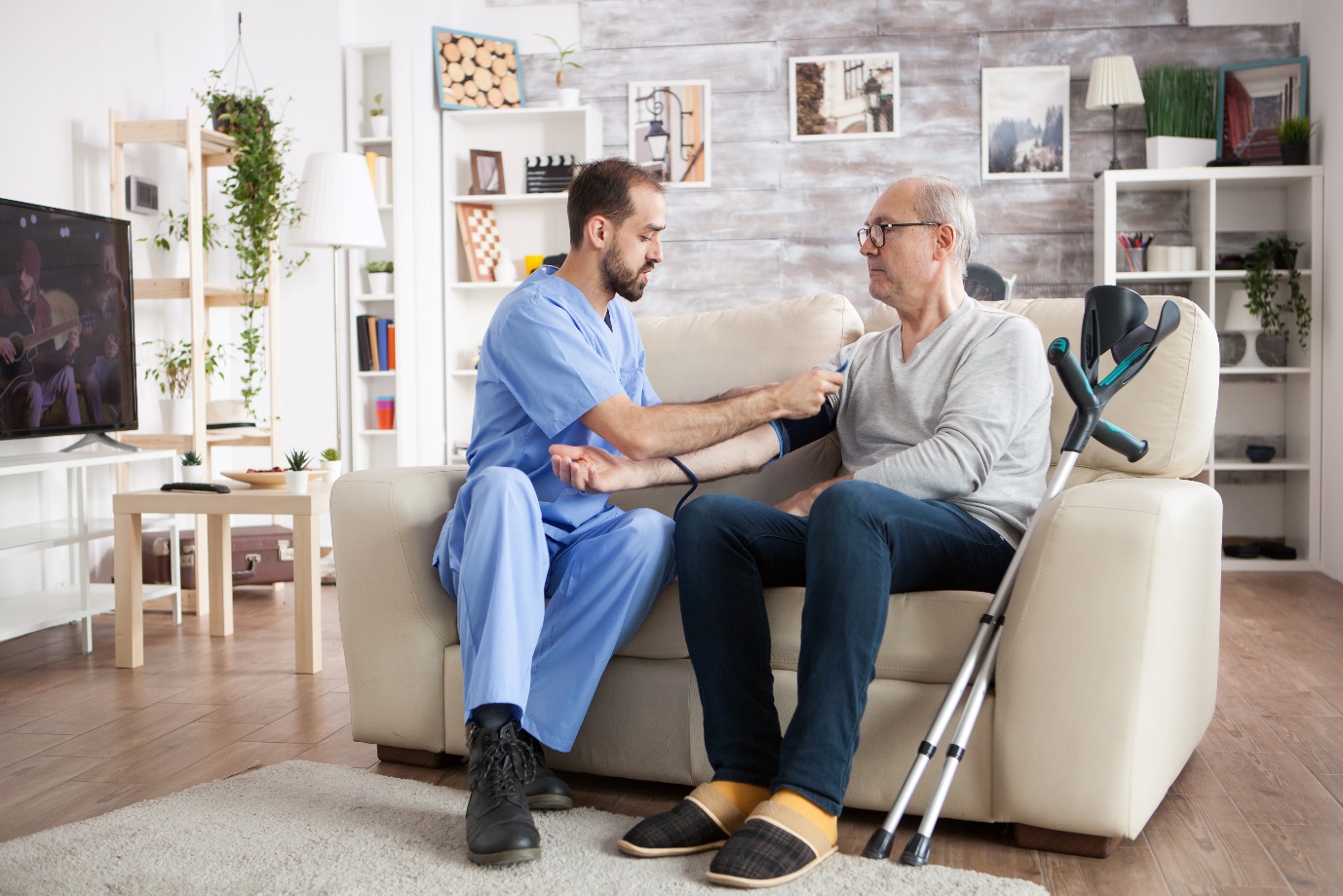 Doctor in nursing home Measuring blood pressure senior man